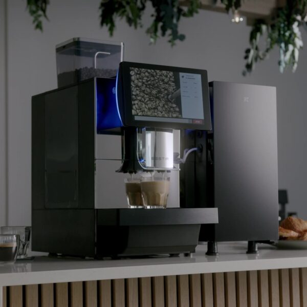 Bestir BM80 bean-to-cup coffee machine on an office counter making two coffees, with touch display and cups visible.